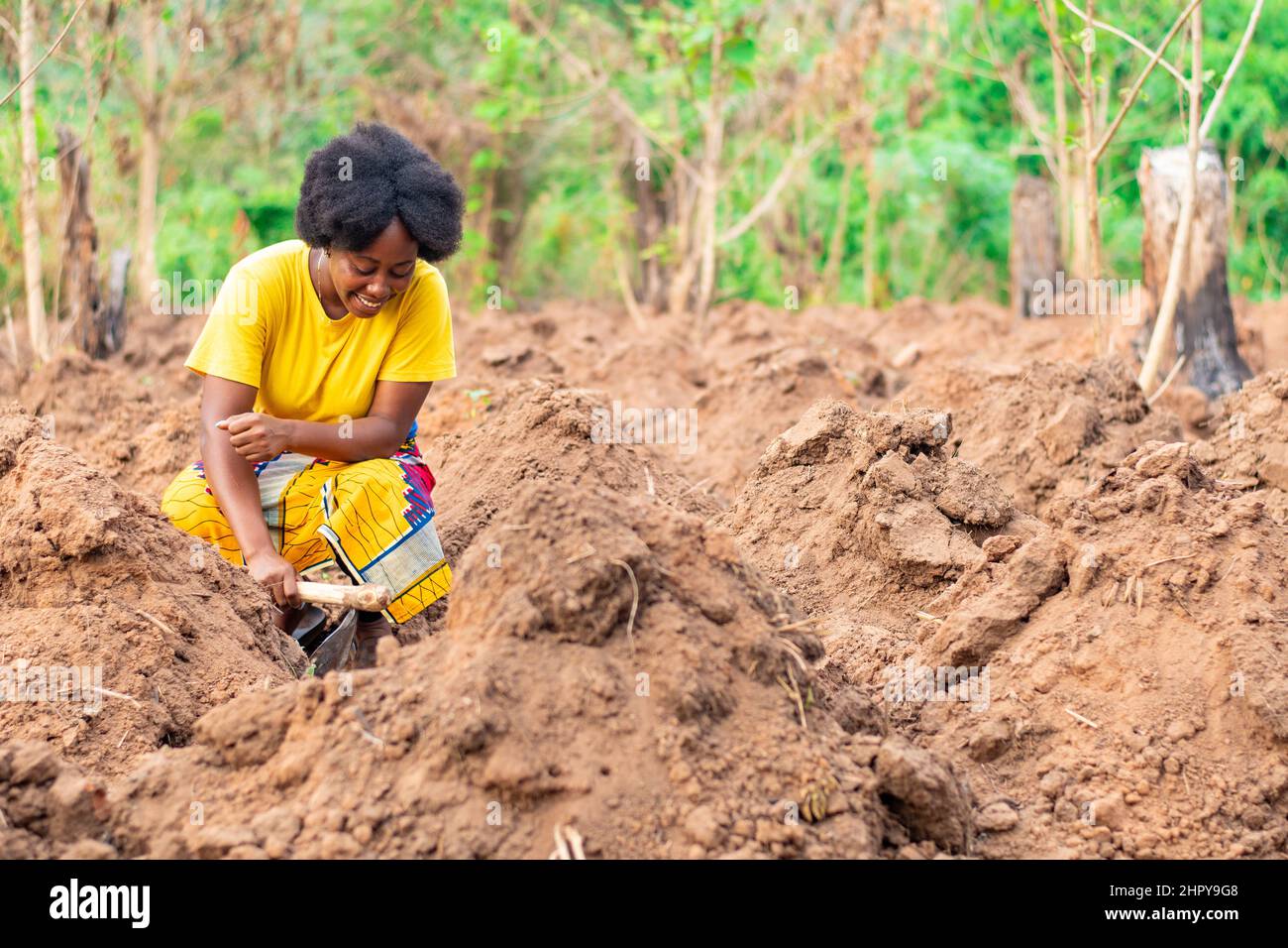 African woman farmer digging ridges on her farm Stock Photo