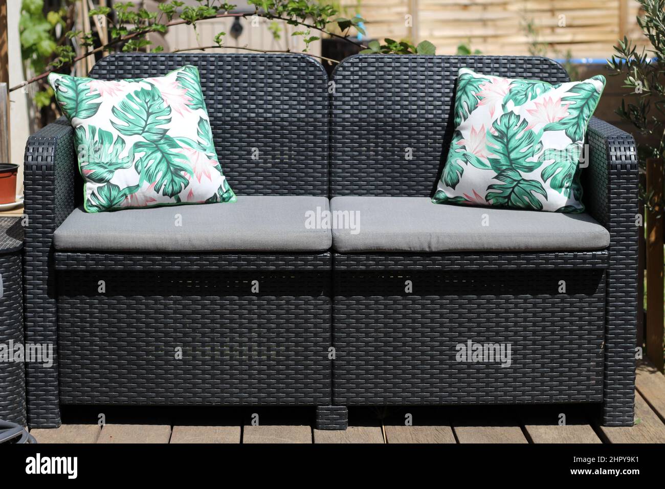Twoseater sofa with its cushions on a terrace under a bright sunlight