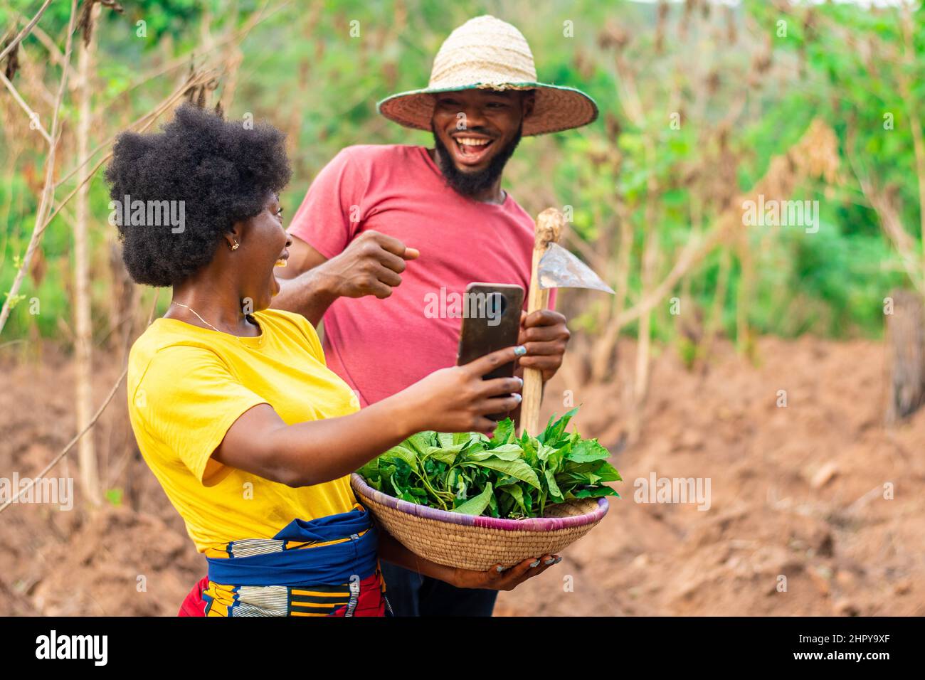 An African couple doing selfie while carrying basket of vegetable Stock Photo