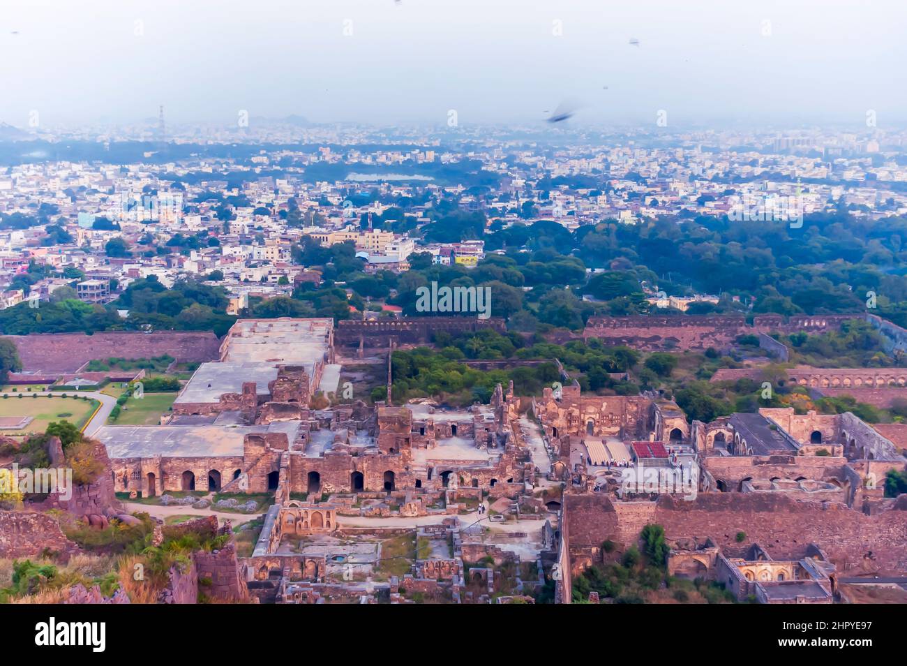 A view of the inside of the Golconda Fort in Hyderabad, Telangana, India. The skyline of the city with a layer of smog is visible in the background. Stock Photo