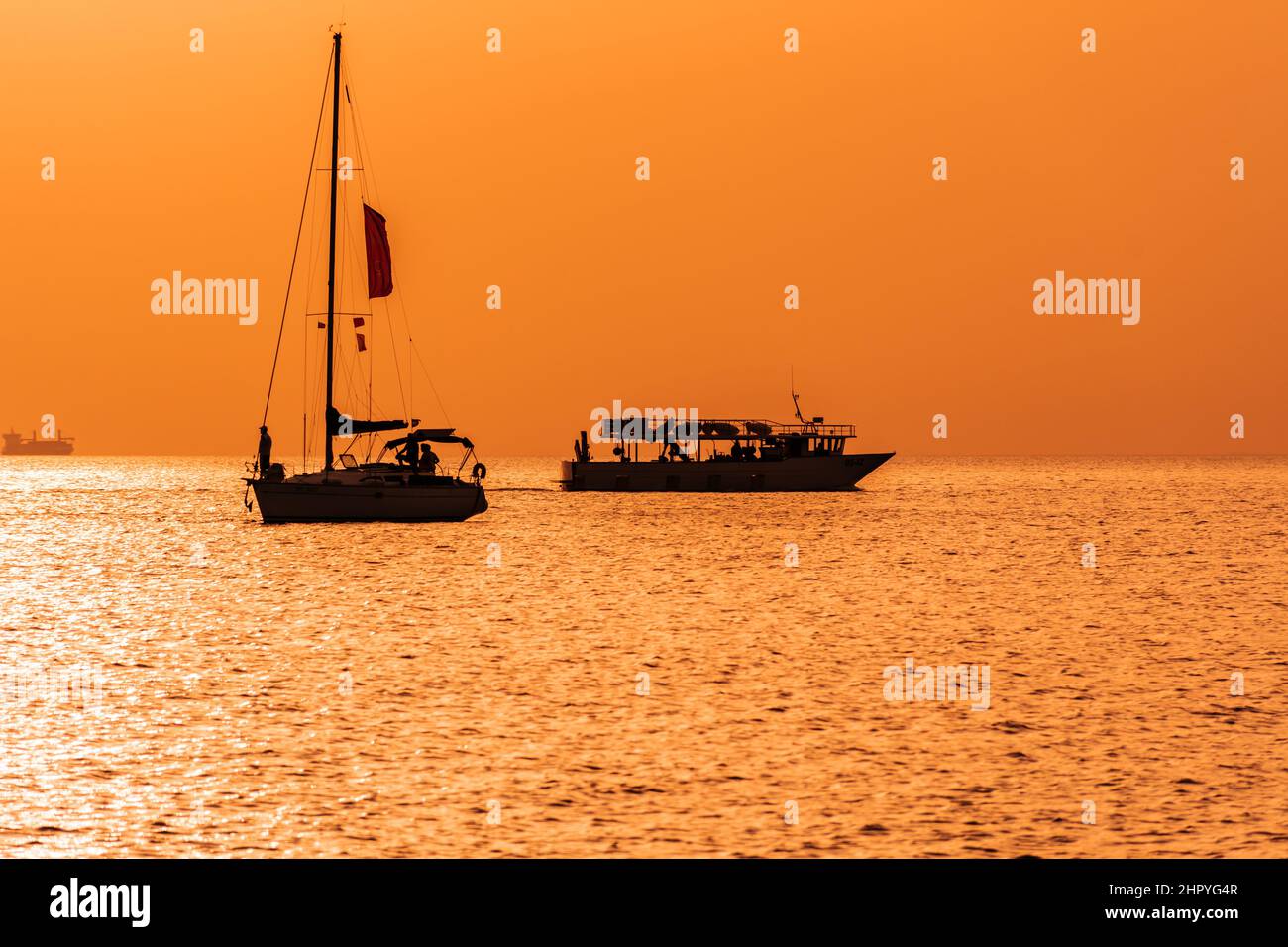 Silhouette of sailing boats on the sunset Stock Photo - Alamy