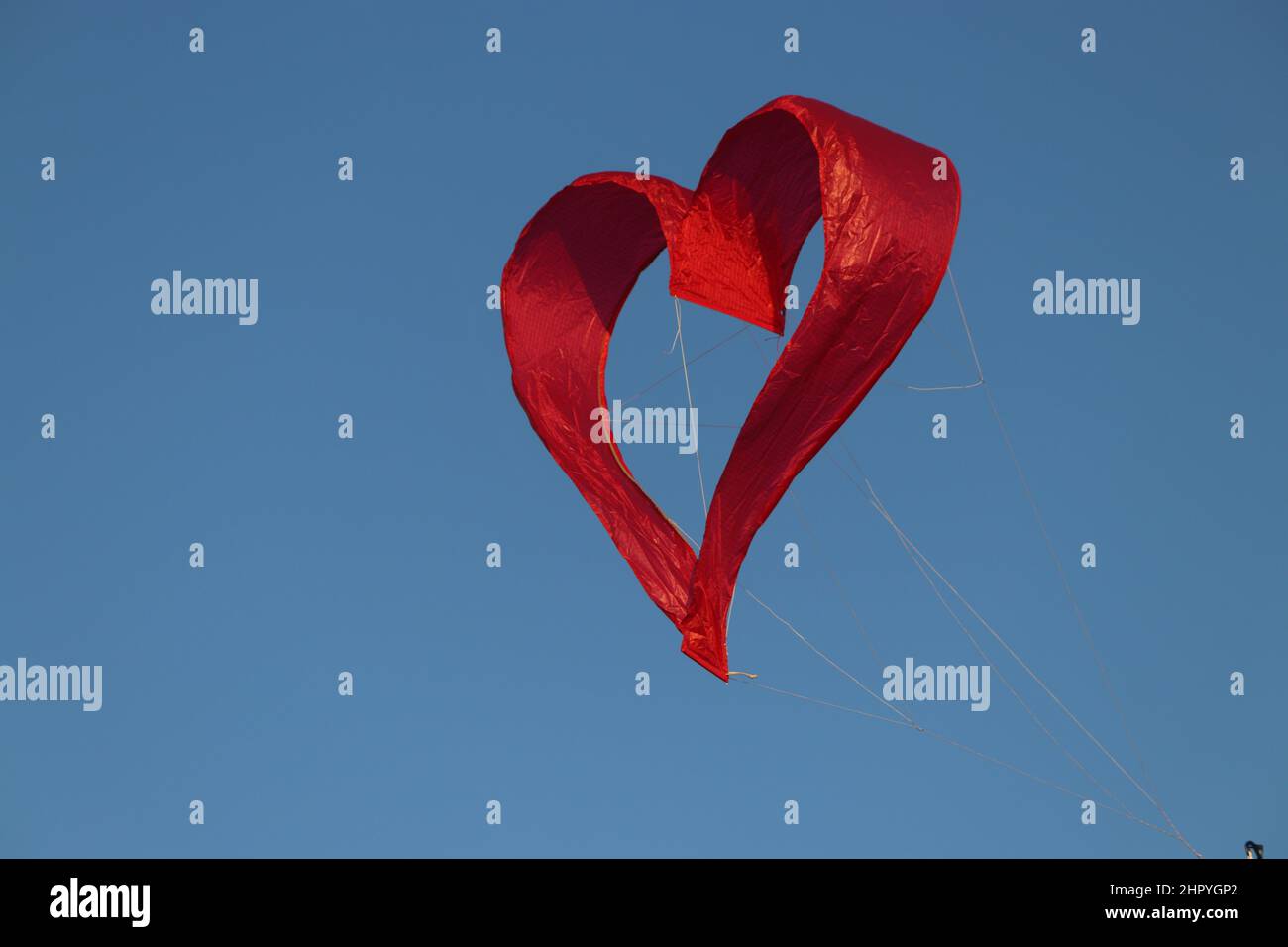 Floating heart shaped balloon float in a blue sky Stock Photo - Alamy