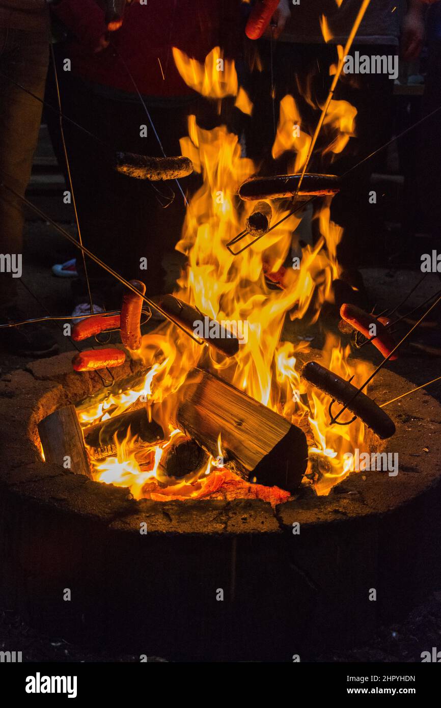 Closeup of a camp fire with flames and wood pieces at night Stock Photo ...