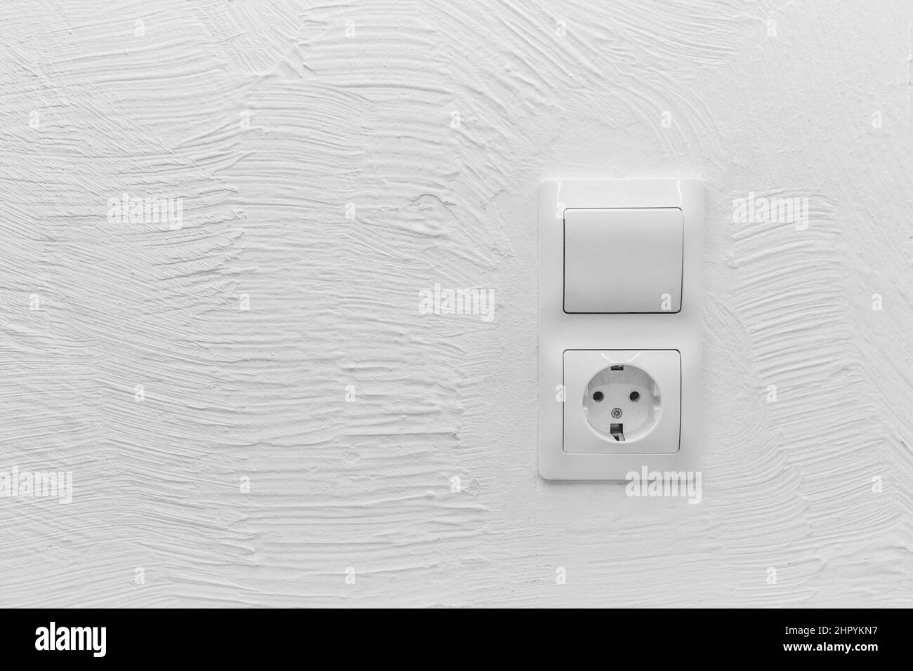 Socket and light off turn on button on the background of the switch white wall of the house, close up. Stock Photo