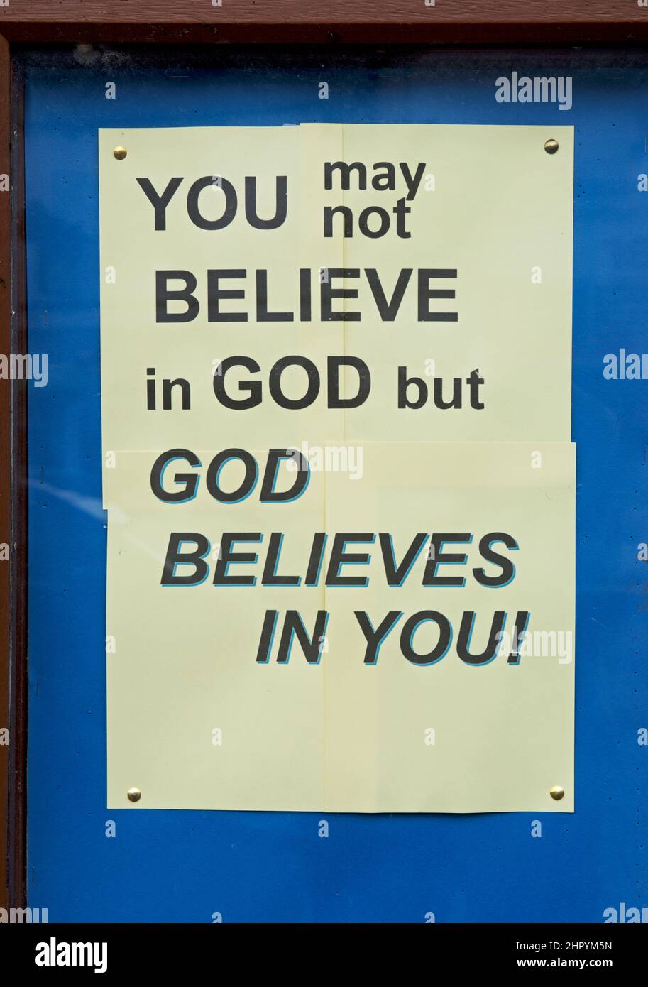 Notice displayed in front of church: You may nor believe in God, but God believes in you! Stock Photo