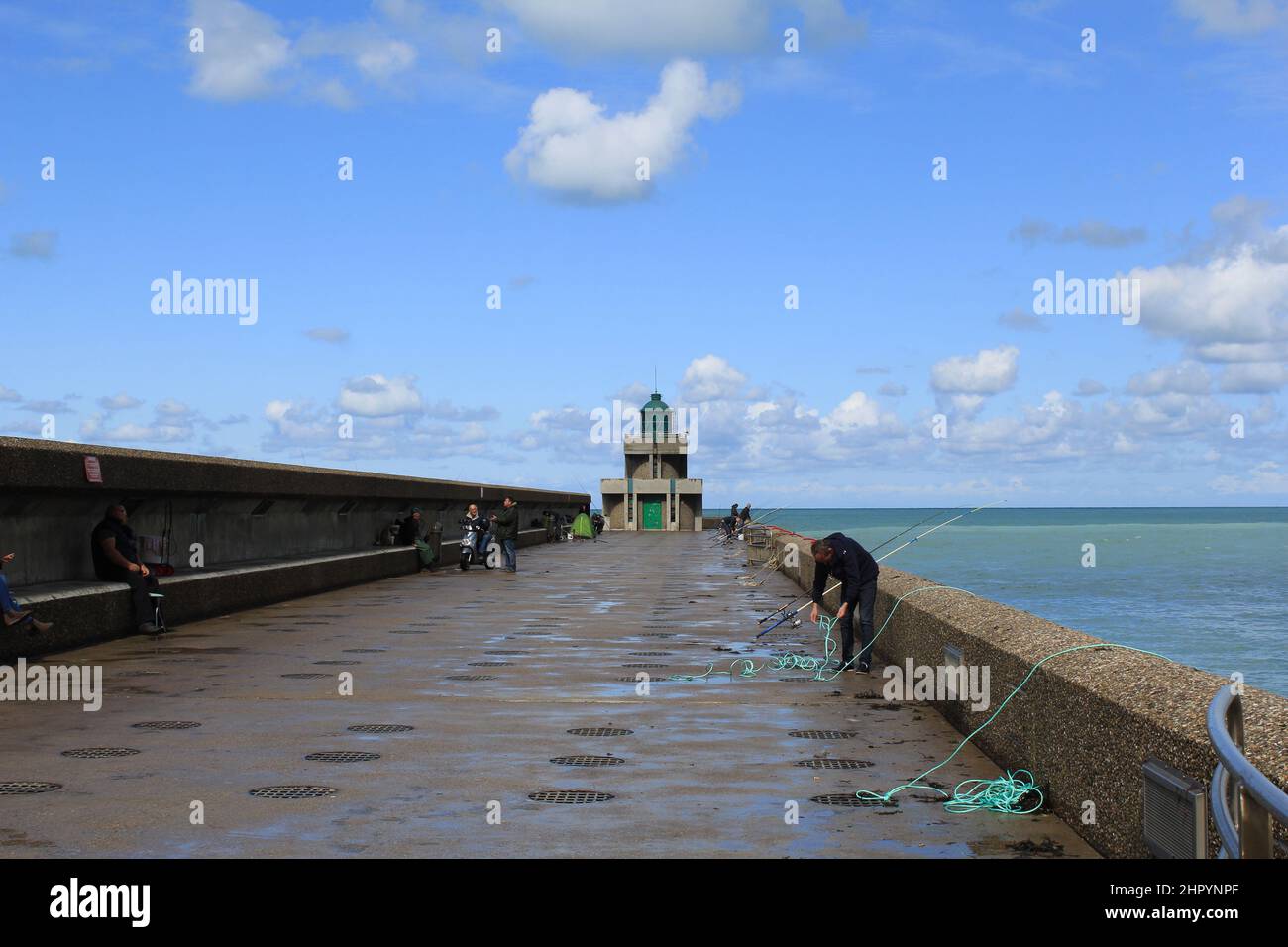 the pier in dieppe with fishermen at the french coast in normandy after rain in september Stock Photo