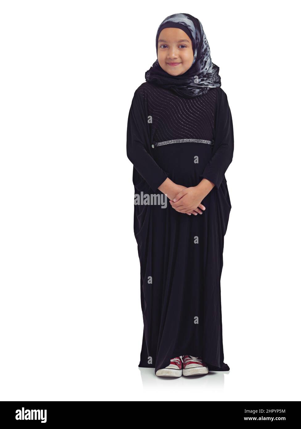 Teaching tradition. Studio portrait of a cute little muslim girl isolated on white. Stock Photo
