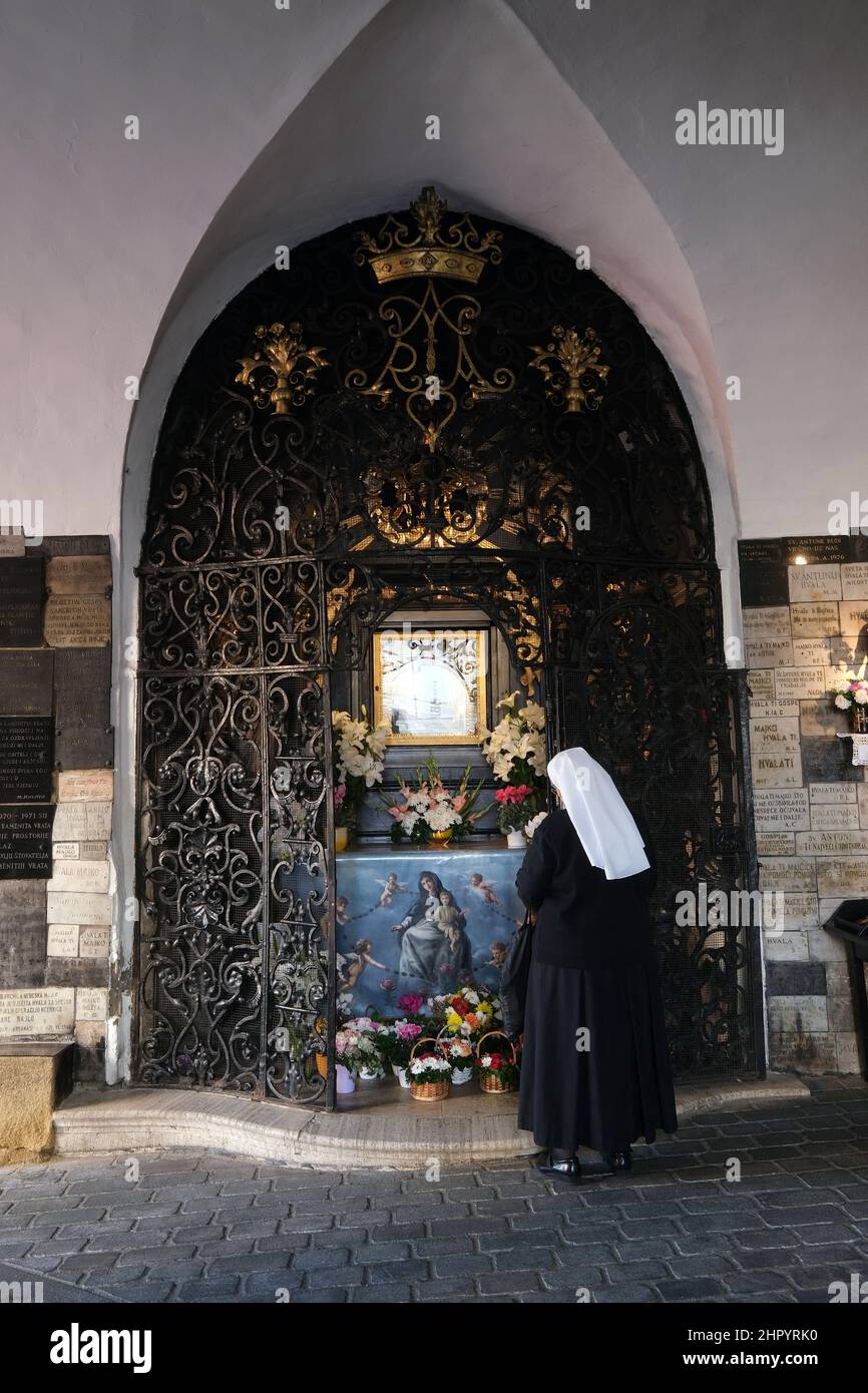 The nun prays in chapel of Our Lady of the Kamenita vrata (Stone Gate) in Zagreb, Croatia Stock Photo