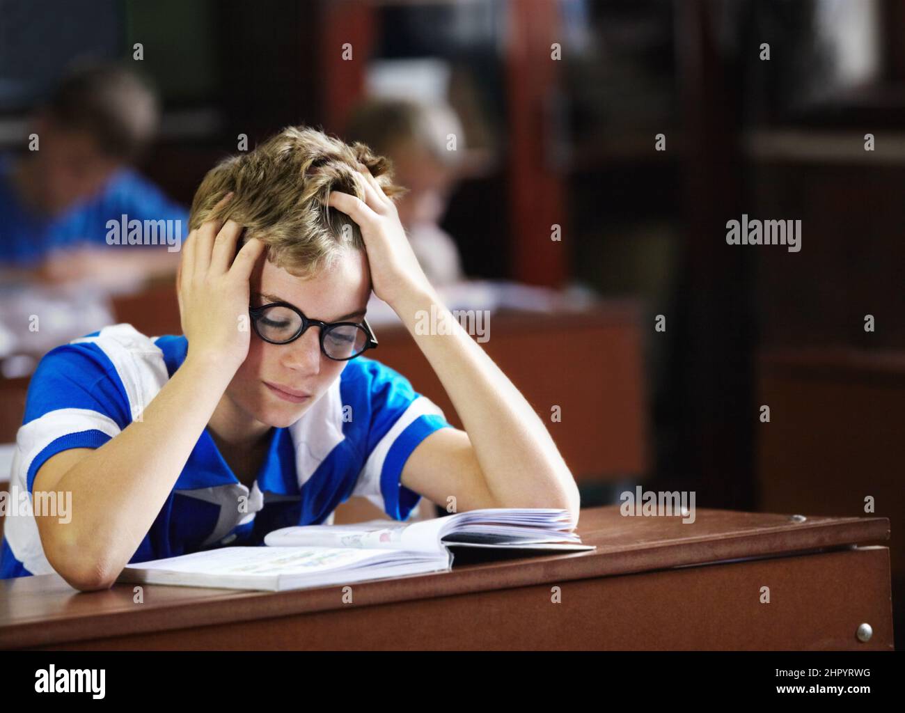 I just cant get this right - Learning disabilities. Young boy feeling overcome with boredom in the classroom. Stock Photo