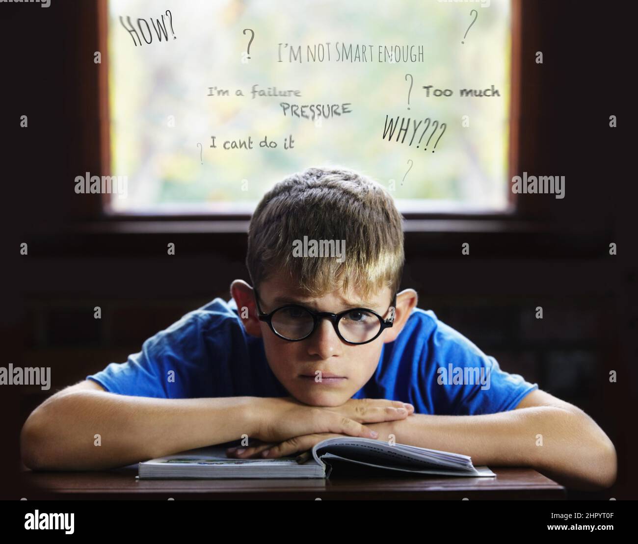 Struggling to learn - Learning disabilities. Young boy feeling overcome with boredom in the classroom. Stock Photo