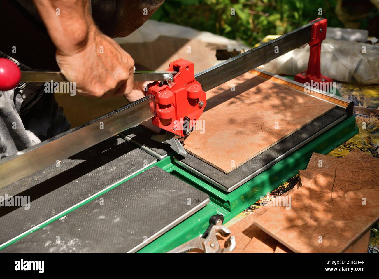 The tiler cuts the tile using a masonry cutter Stock Photo