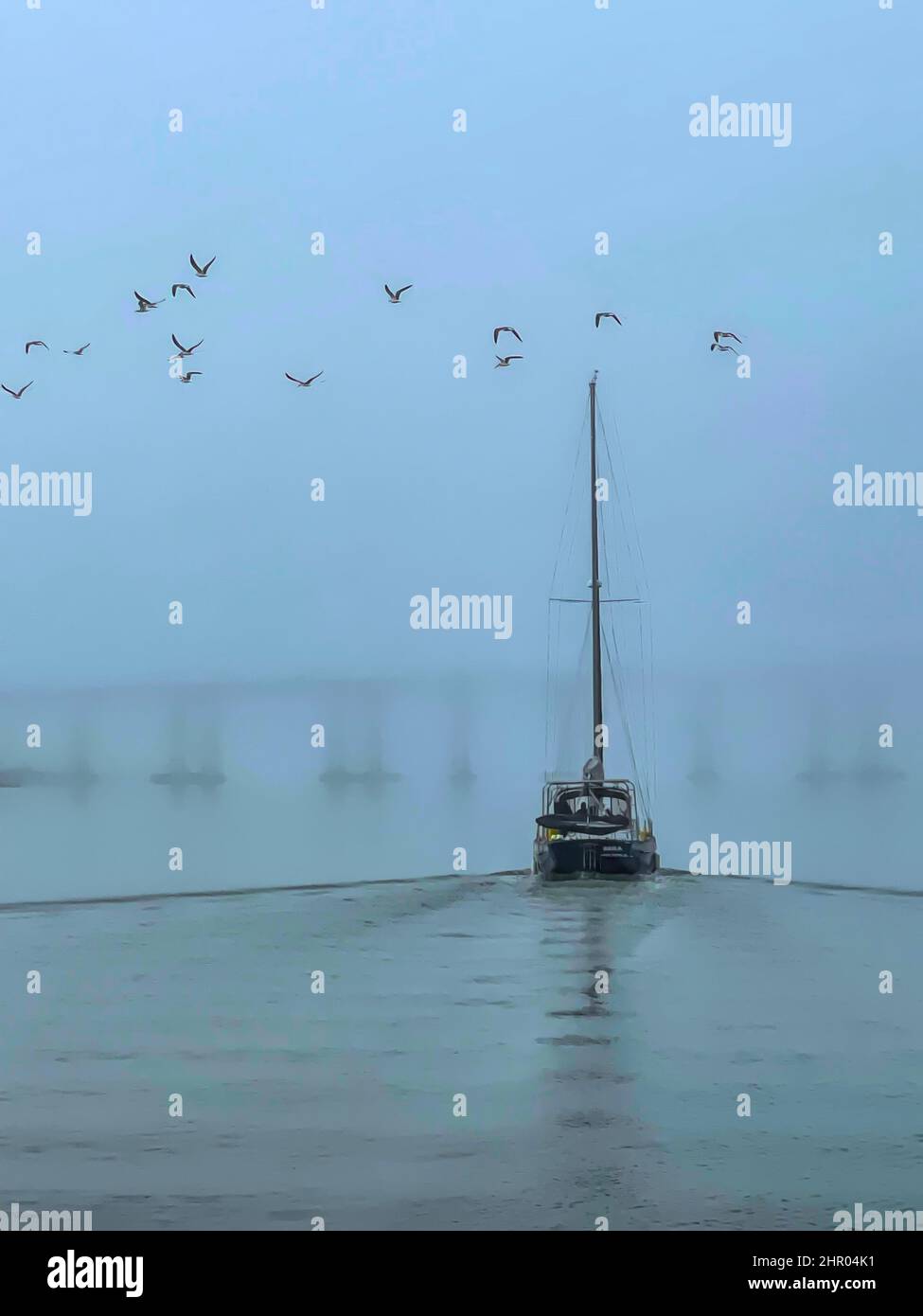 Sailboat preparing to go under the Bridge of Lions, St. Augustine, Fl in a thick fog. Stock Photo