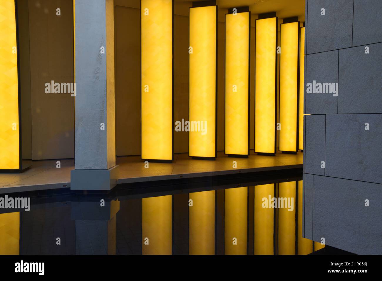 Contemporary water reflected interior walls illuminated by large yellow rectangular lights. Stock Photo