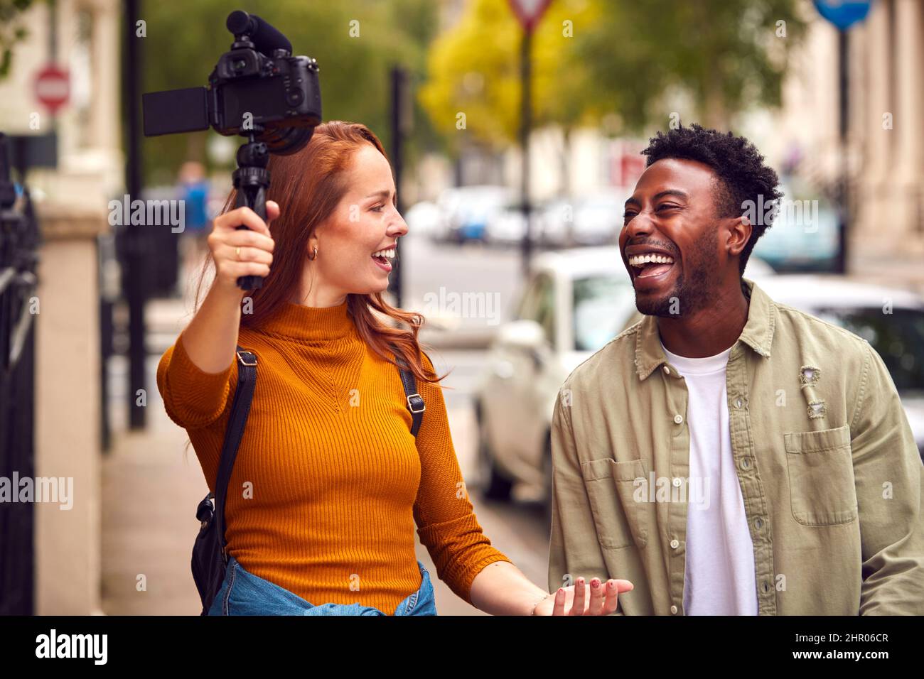 Young Couple Travelling Through City Together Vlogging To Video Camera On Handheld Tripod Stock Photo
