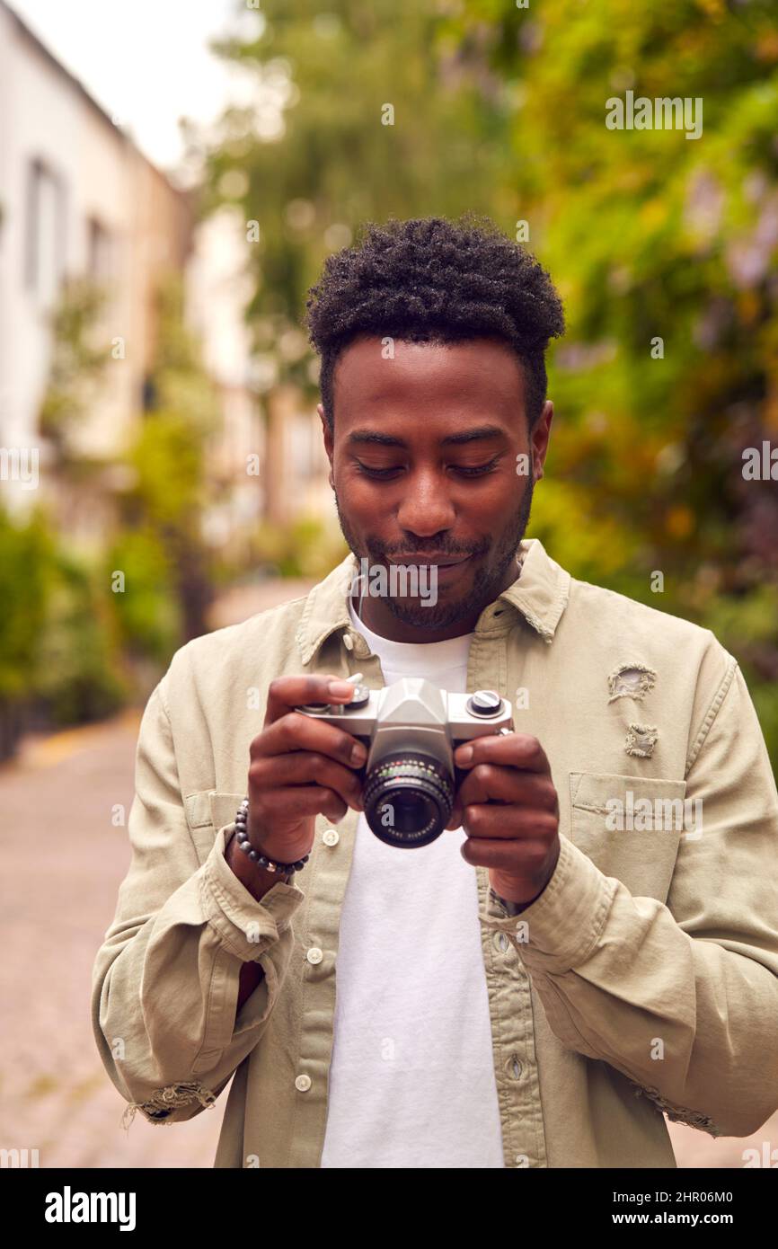 Young Man In City Taking Photo On Digital Camera To Post To Social Media Stock Photo