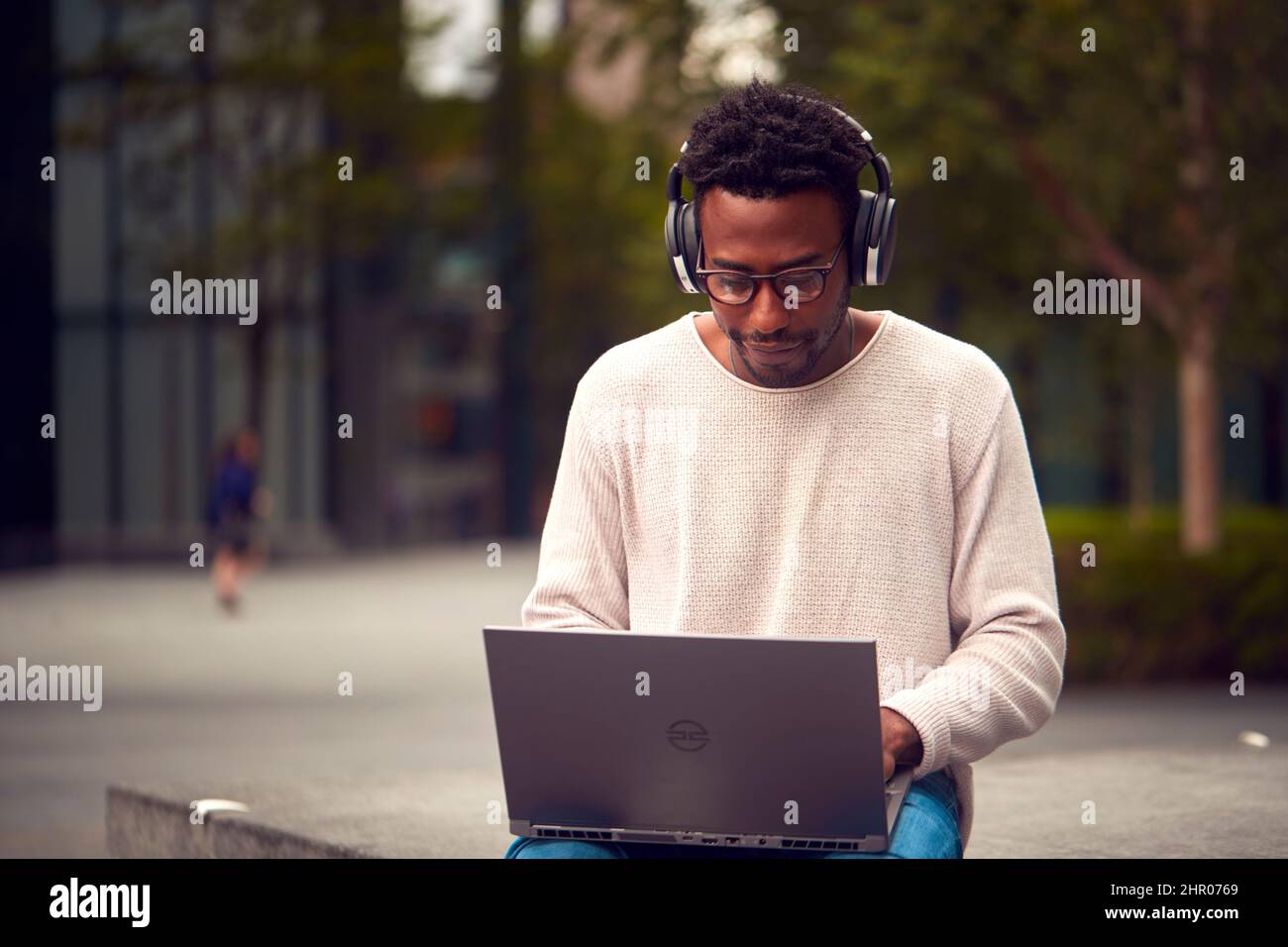 Male Vlogger Or Social Influencer Travelling Through City For Social Media Using Laptop Outdoors Stock Photo