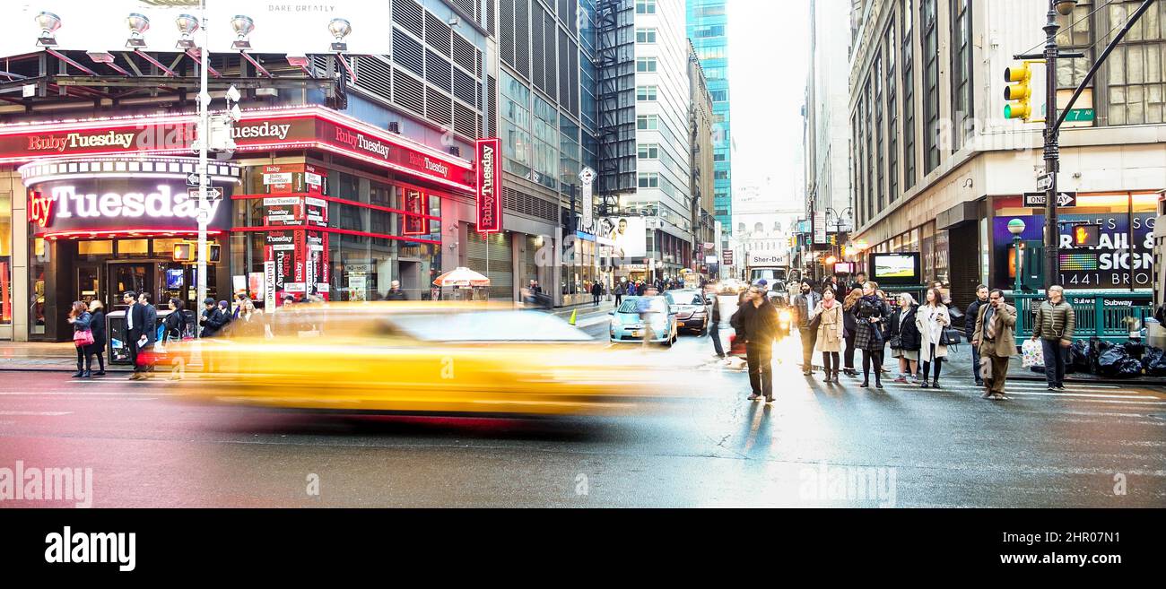 NEW YORK - MARCH 27, 2015: everyday life with blurred yellow taxi cab speeding near Times Square in Manhattan downtown before sunset Stock Photo