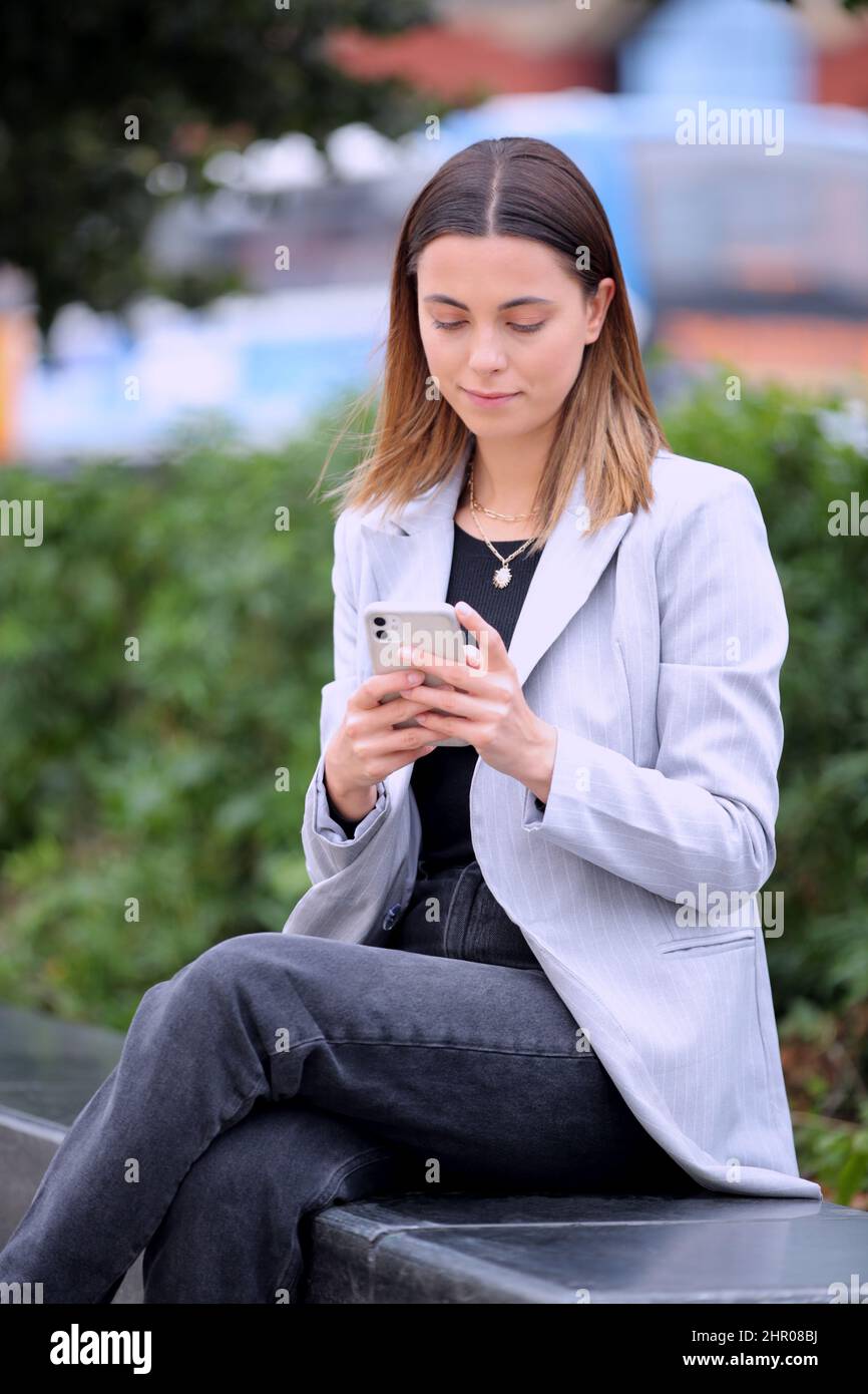 Female Office Worker Outdoors Using Mobile Phone During Break Stock Photo