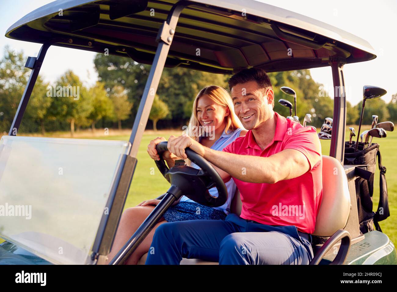 Couple Driving Buggy Playing Round On Golf Together Stock Photo