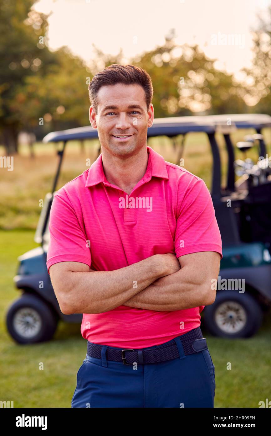 Portrait Of Smiling Male Golfer Standing By Buggy On Golf Course Stock Photo