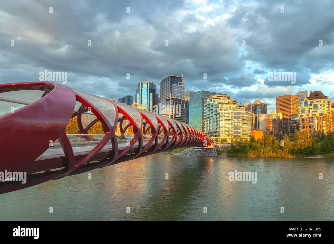 Peace Bridge over the Bow River with Calgary downtown in background, Alberta, Canada, at sunset. Stock Photo