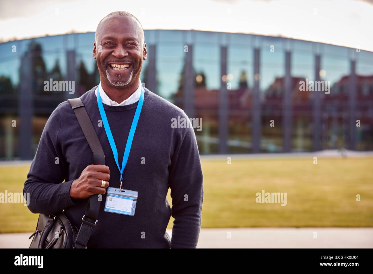 Portrait Of Male University Or College Tutor Outdoors With Modern Campus Building In Background Stock Photo