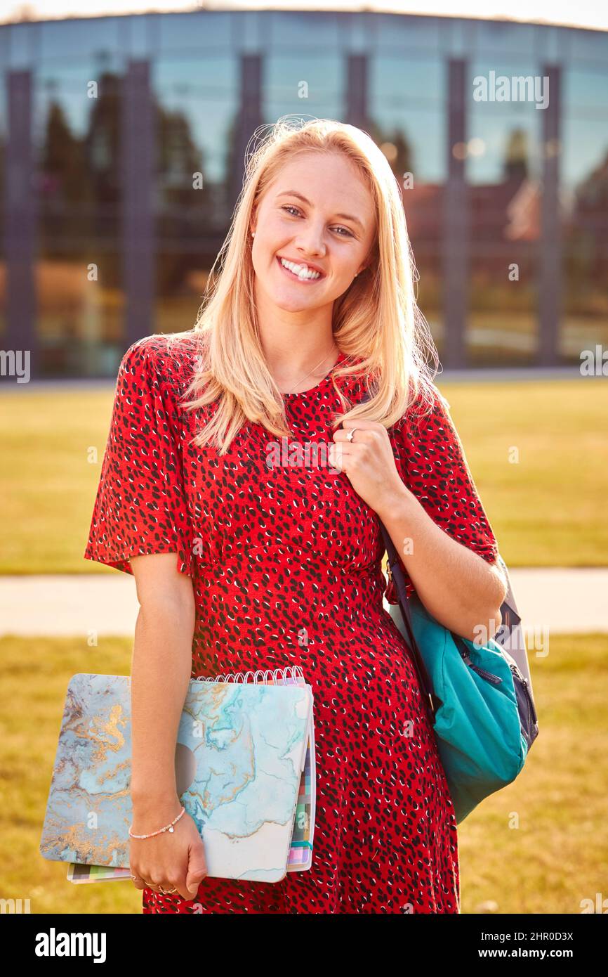 Portrait Of Female University Or College Student Standing Outdoors By Modern Campus Building Stock Photo