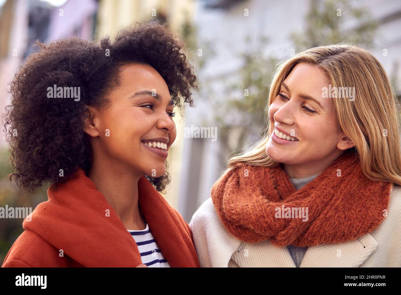 Outdoor Portrait Of Smiling Female Friends Wearing Coat And Scarf In Autumn Or Fall Stock Photo