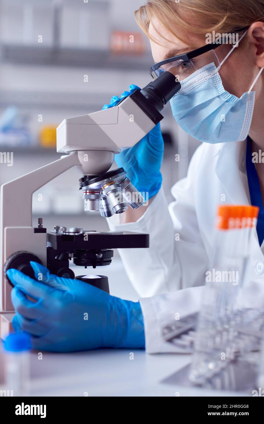 Close Up Of Female Lab Worker Wearing PPE And Safety Glasses Looking At ...