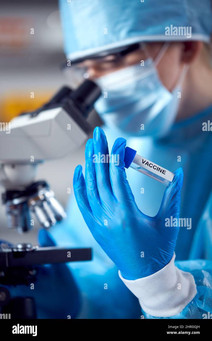 Close Up Of Female Lab Worker Wearing PPE Researching Vaccine With ...