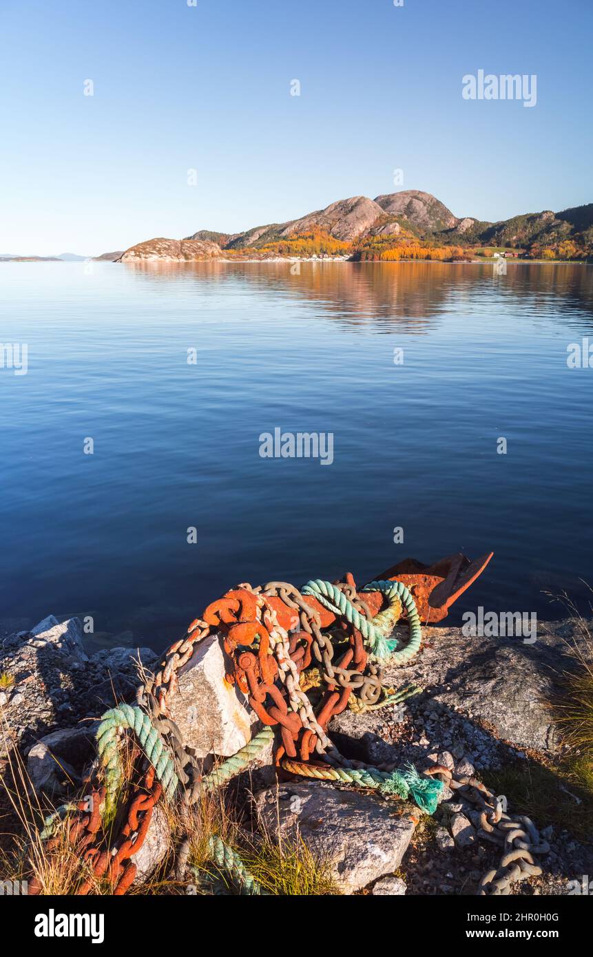 Vertical coastal Norwegian landscape with rusty anchor and chains on a foreground, Snillfjord, Sor-Trondelag, Vingvagen fishing camp Stock Photo
