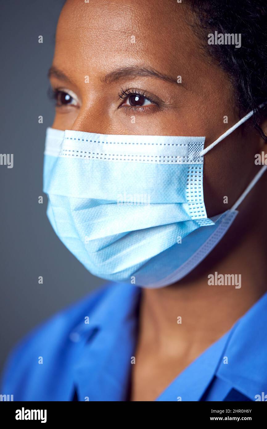 Close Up Studio Portrait Of Female Nurse Wearing Uniform And Face Mask Stock Photo