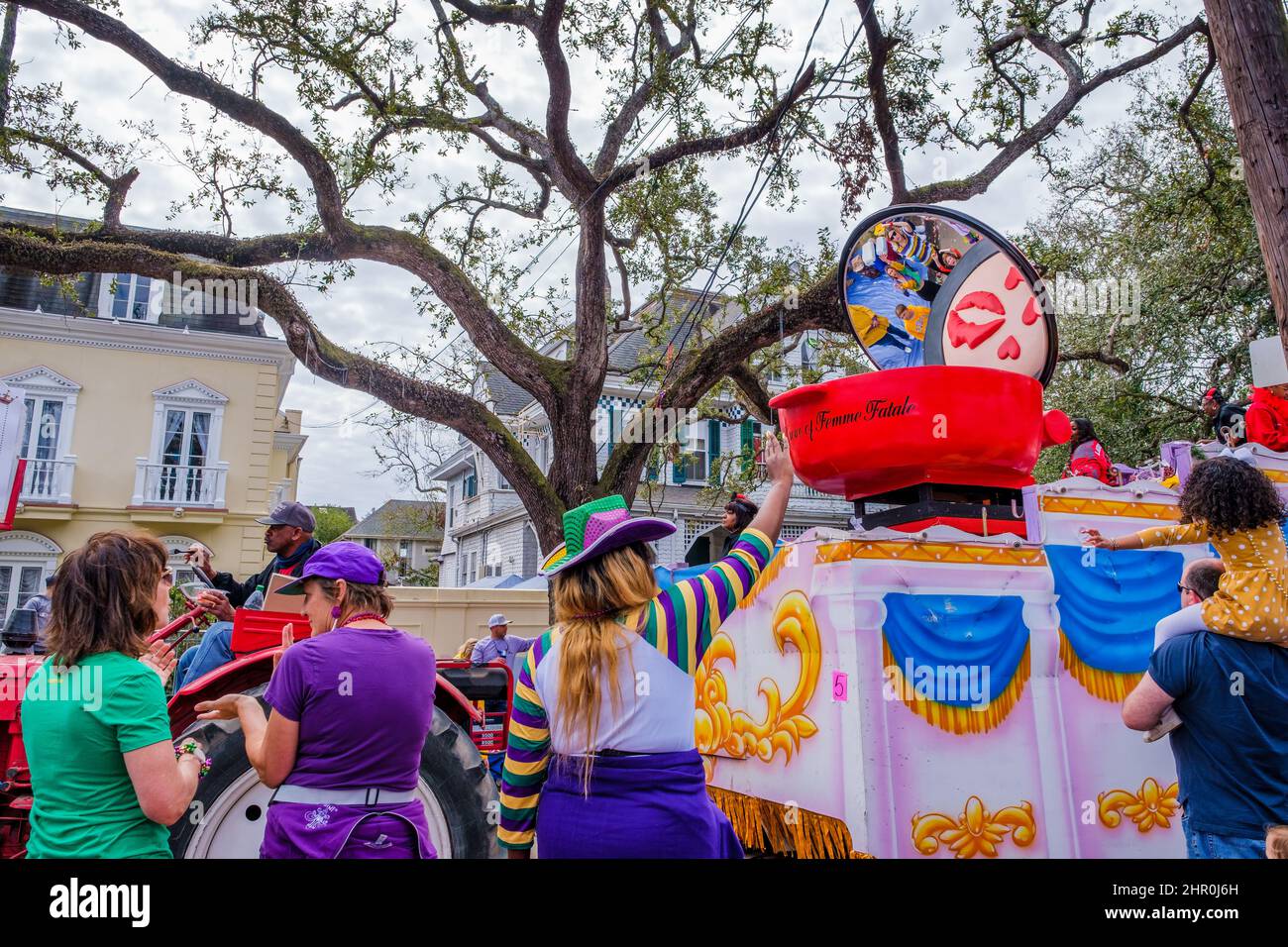 NEW ORLEANS, LA, USA - FEBRUARY 20, 2022: Parade watchers in Mardi Gras apparel soliciting beads from float riders of Femme Fatale Parade on St. Char Stock Photo
