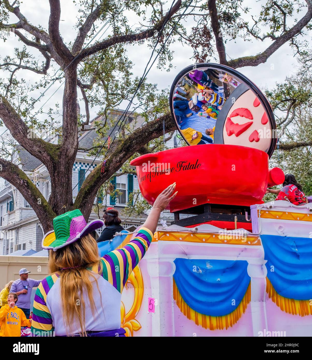 NEW ORLEANS, LA, USA - FEBRUARY 20, 2022: Woman in Mardi Gras apparel with outstretched arm soliciting beads from float riders of Femme Fatale Parade Stock Photo