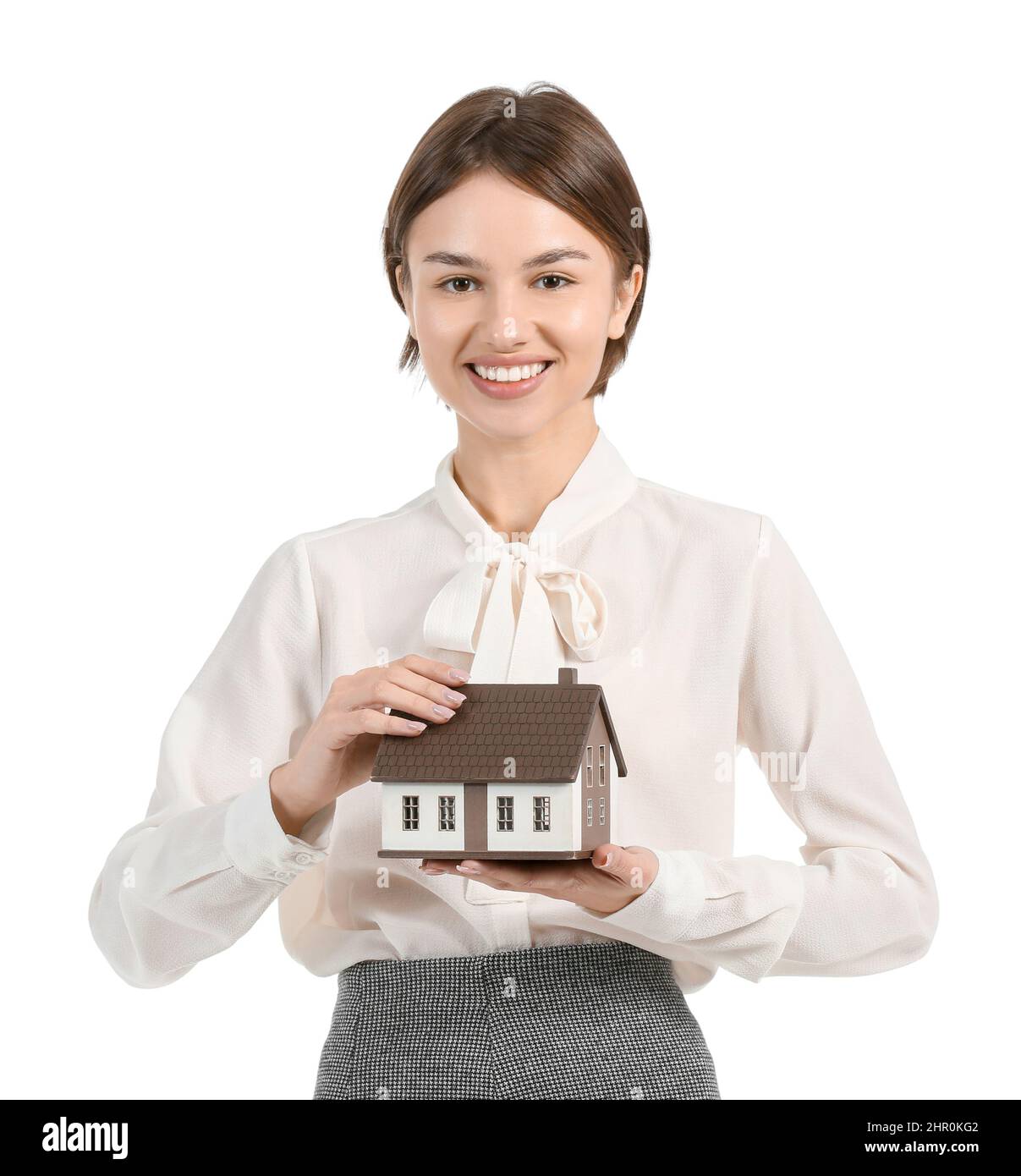 Female real estate agent with figure of house on white background Stock