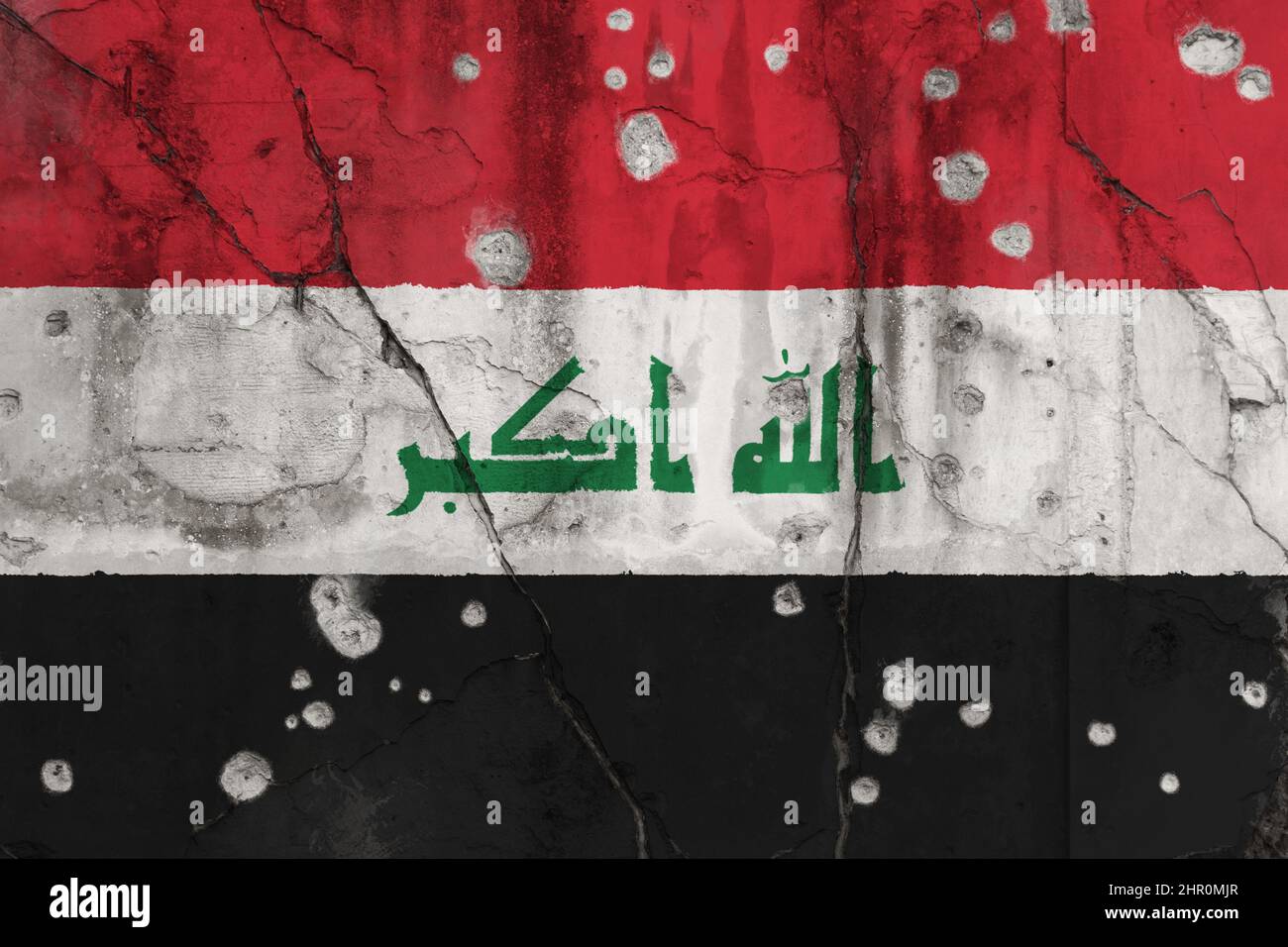 Full frame photo of a weathered flag of Iraq painted on a cracked wall with bullet holes. Islamic State insurgency in Iraq and violence concept. Stock Photo