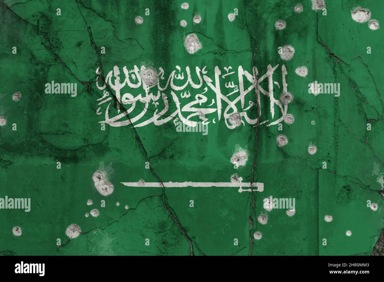 Full frame photo of a weathered flag of Saudi Arabia painted on a cracked wall with bullet holes. Terrorism in Saudi Arabia concept. Stock Photo