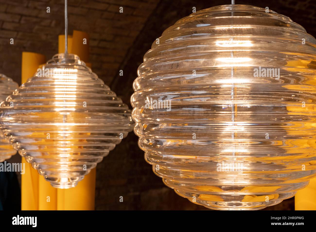 Glass pendant lights by the name Press, hanging in the Tom Dixon flagship store and showroom at Coal Drops Yard, Kings Cross, London UK. Stock Photo