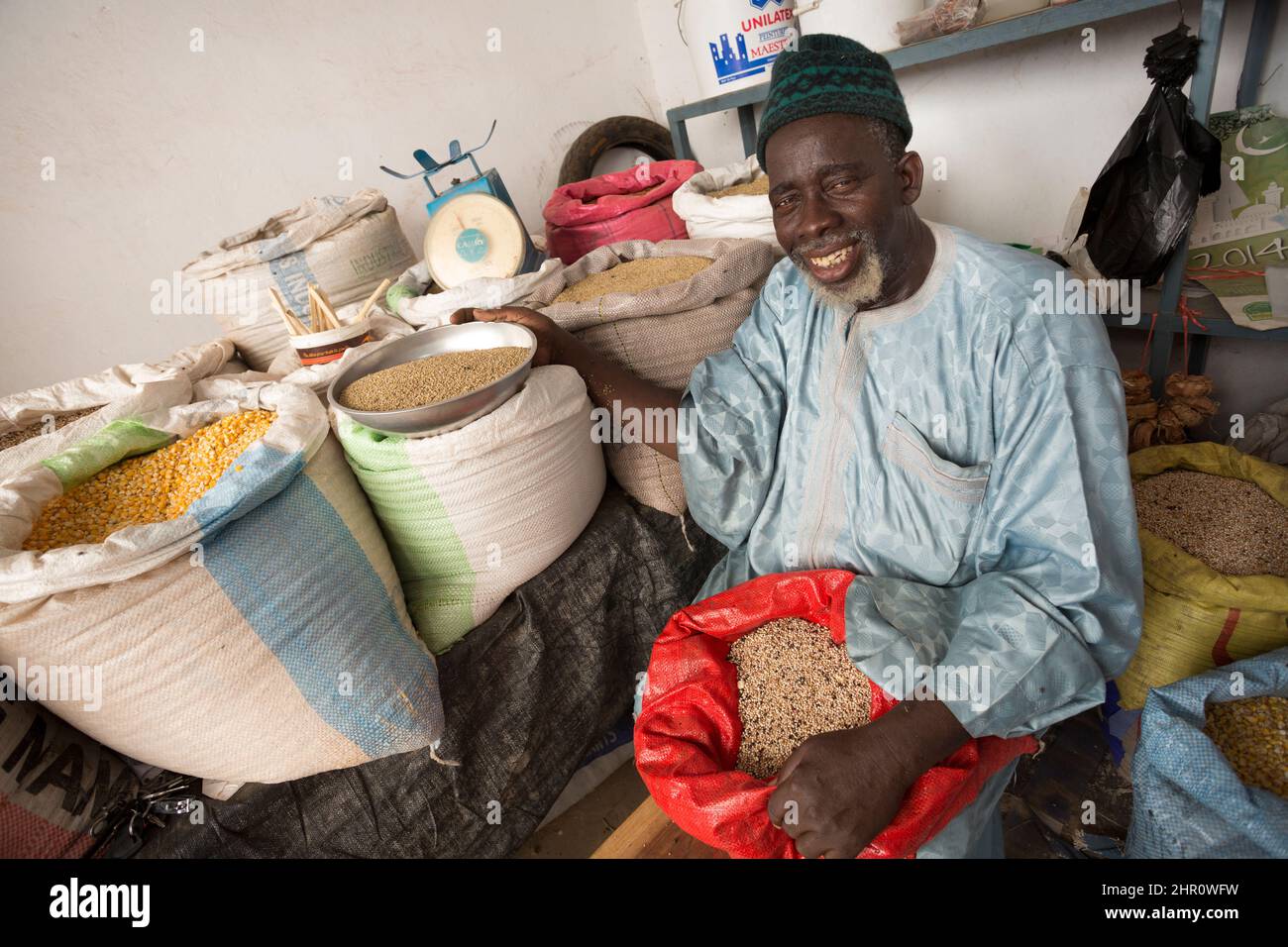 A market vendor sells cereals and pulses at his stall in Kolda, Senegal, West Africa. Stock Photo