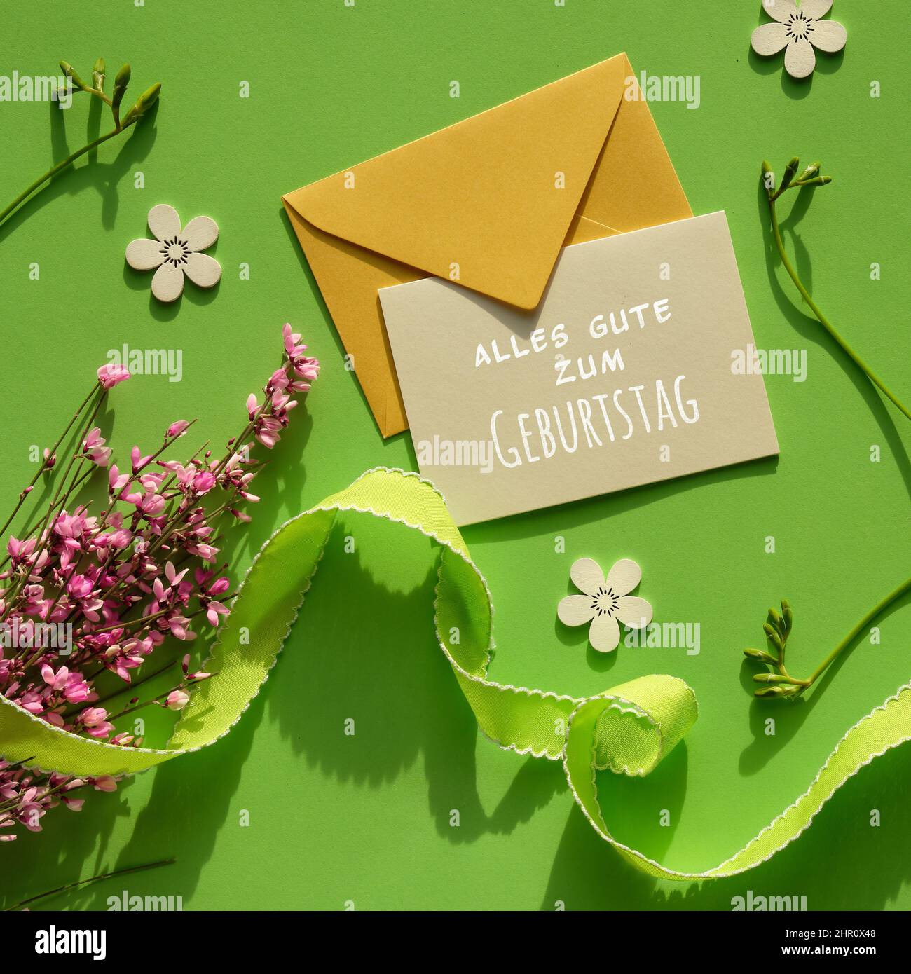 Alles gute zum Geburtstag means Happy Birthday. Envelope, greeting card, spring flowers. Stock Photo