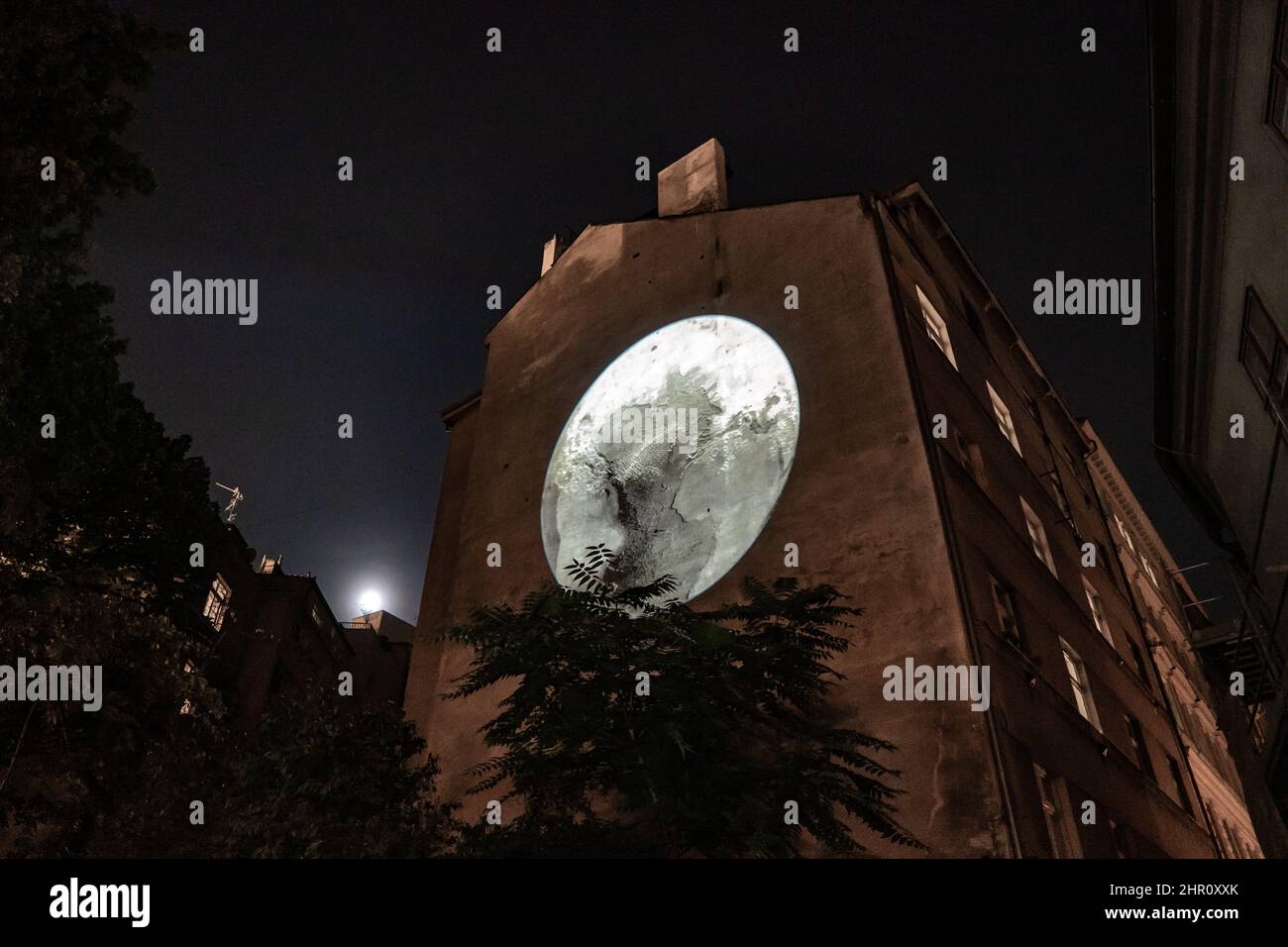 3d mapping of the moon on the wall of a building under a full moon at