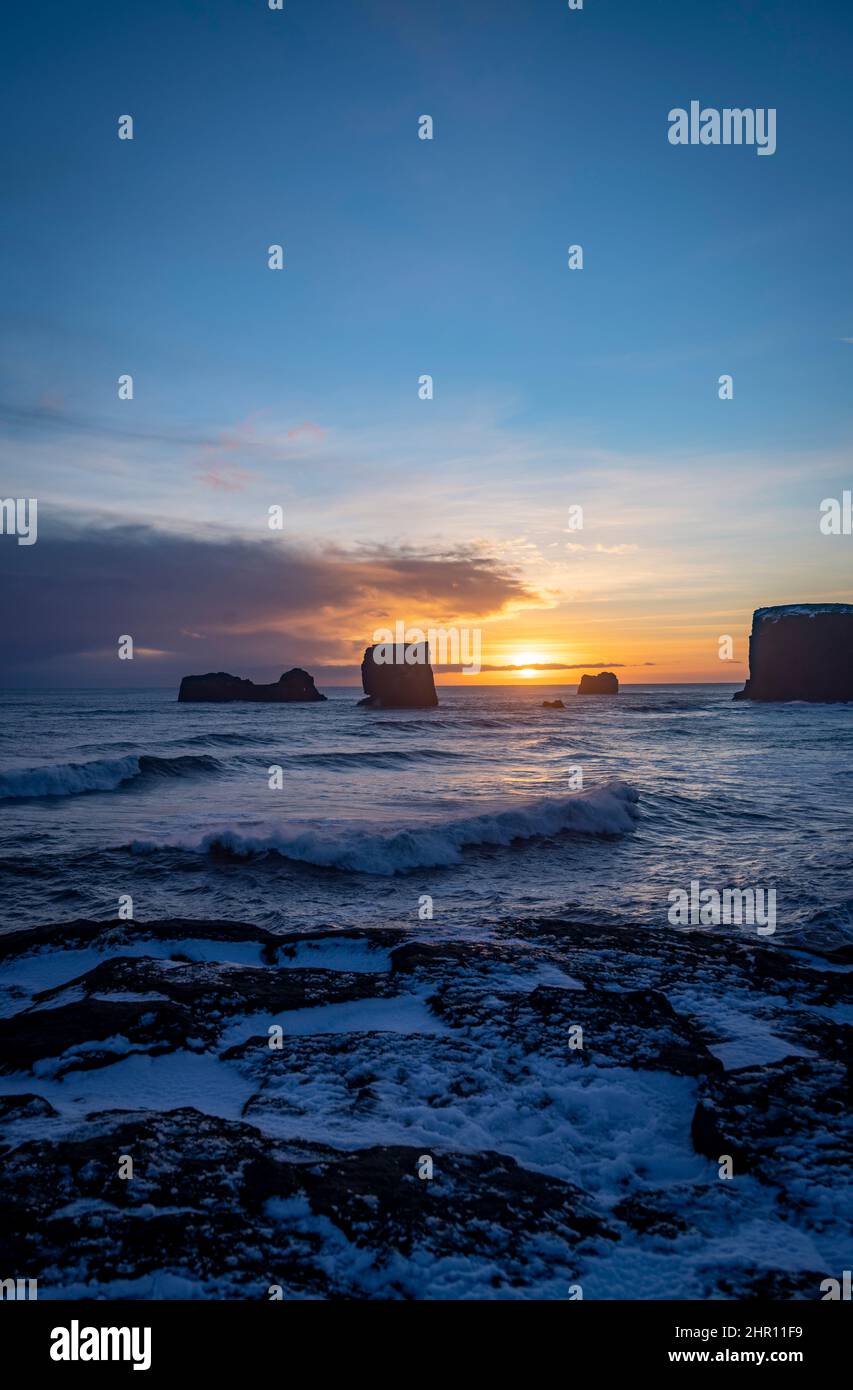 view of rocks and stormy sea at sunset from Dyrholaey Peninsula, southeast Iceland Stock Photo