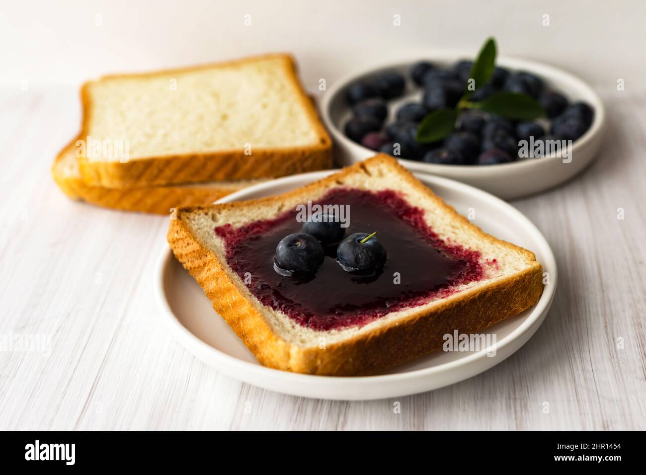 Blueberry jam bread toast and fresh berries on plate. Healthy breakfast concept Stock Photo