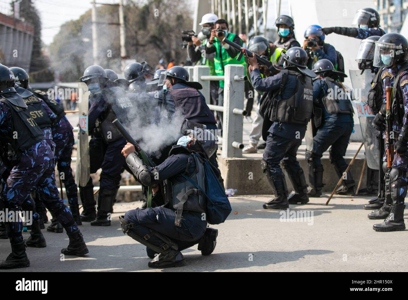 Kathmandu, Nepal. 24th Feb, 2022. A Nepalese policeman fires tear gas  canister during the demonstration. Different political parties youth wings  clashed with Nepal police outside Federal Parliament in protest against the  US$