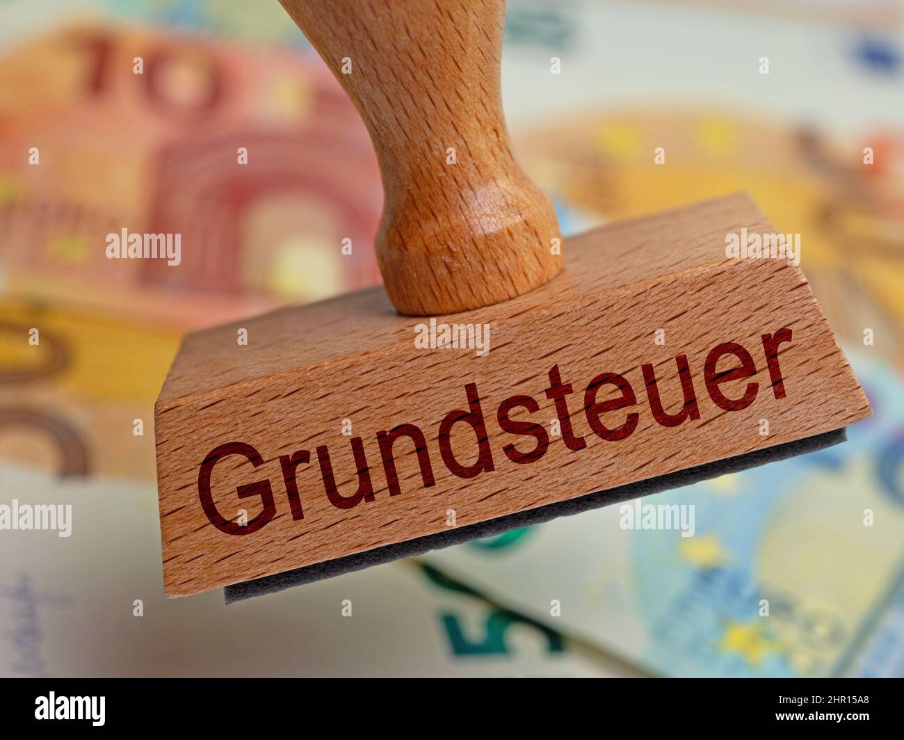 Stamp with the imprint 'Grundsteuer', translation 'Property tax' in front of banknotes Stock Photo
