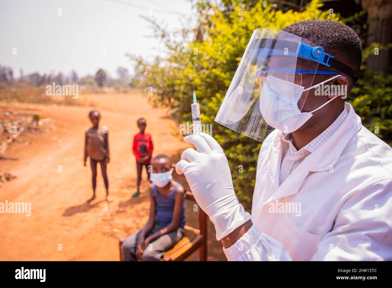 An African doctor is about to vaccinate children to prevent coronavirus infection. Vaccination concept in africa Stock Photo