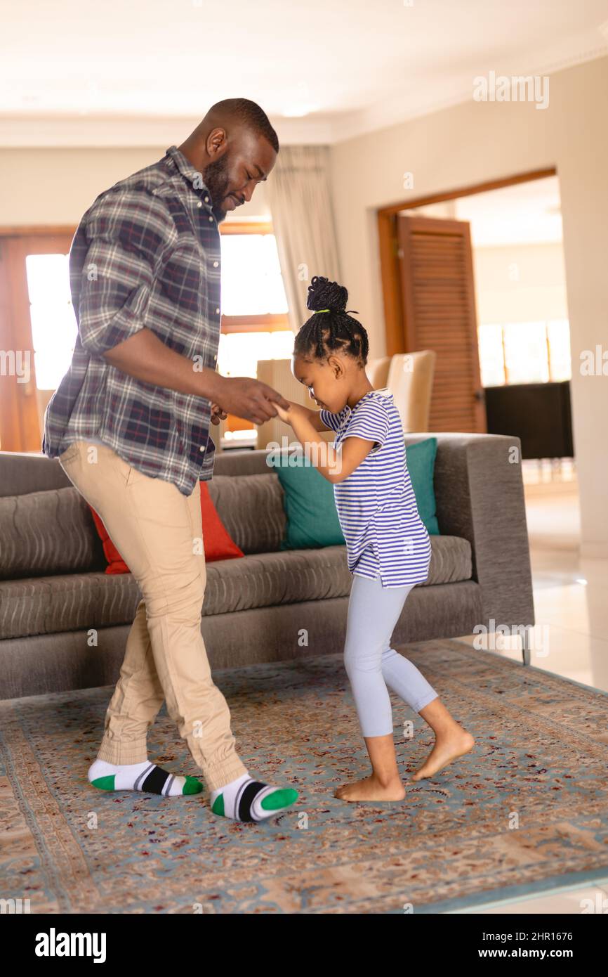 African american father and daughter holding hands while dancing ...