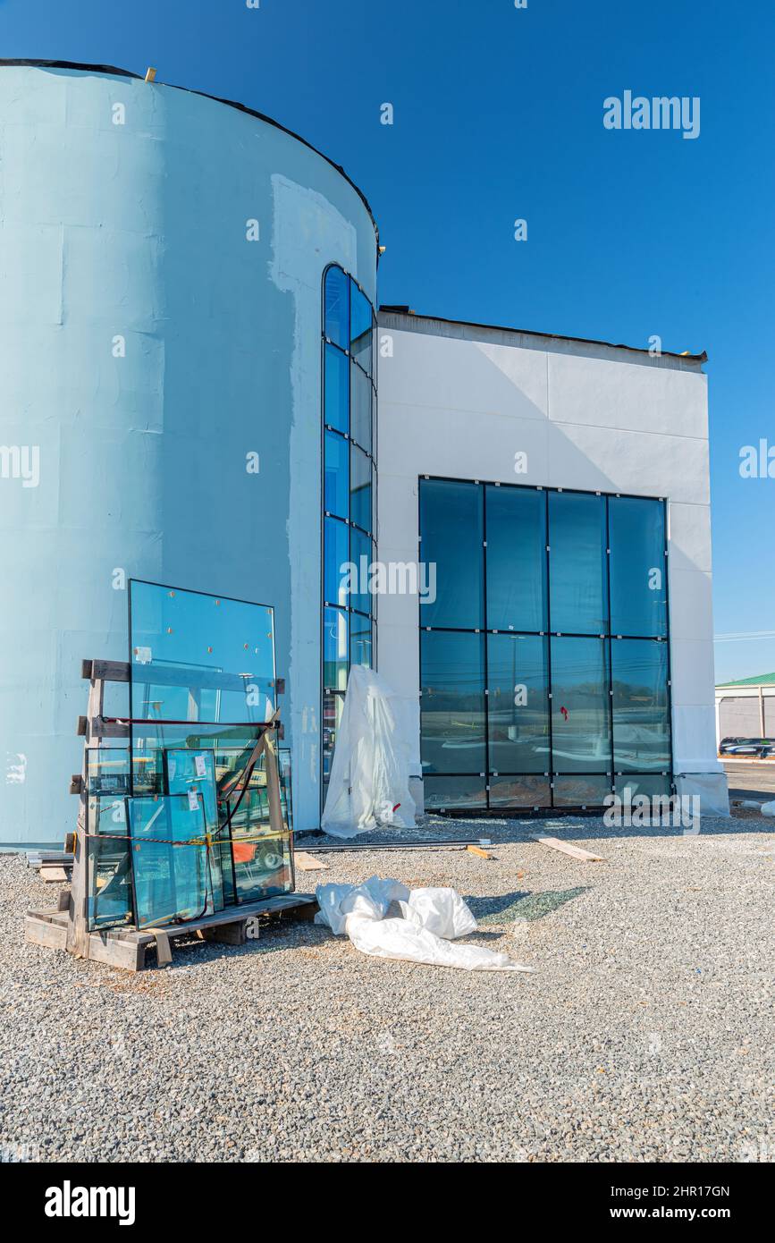 Vertical shot of glass being installed in a commercial building. Stock Photo
