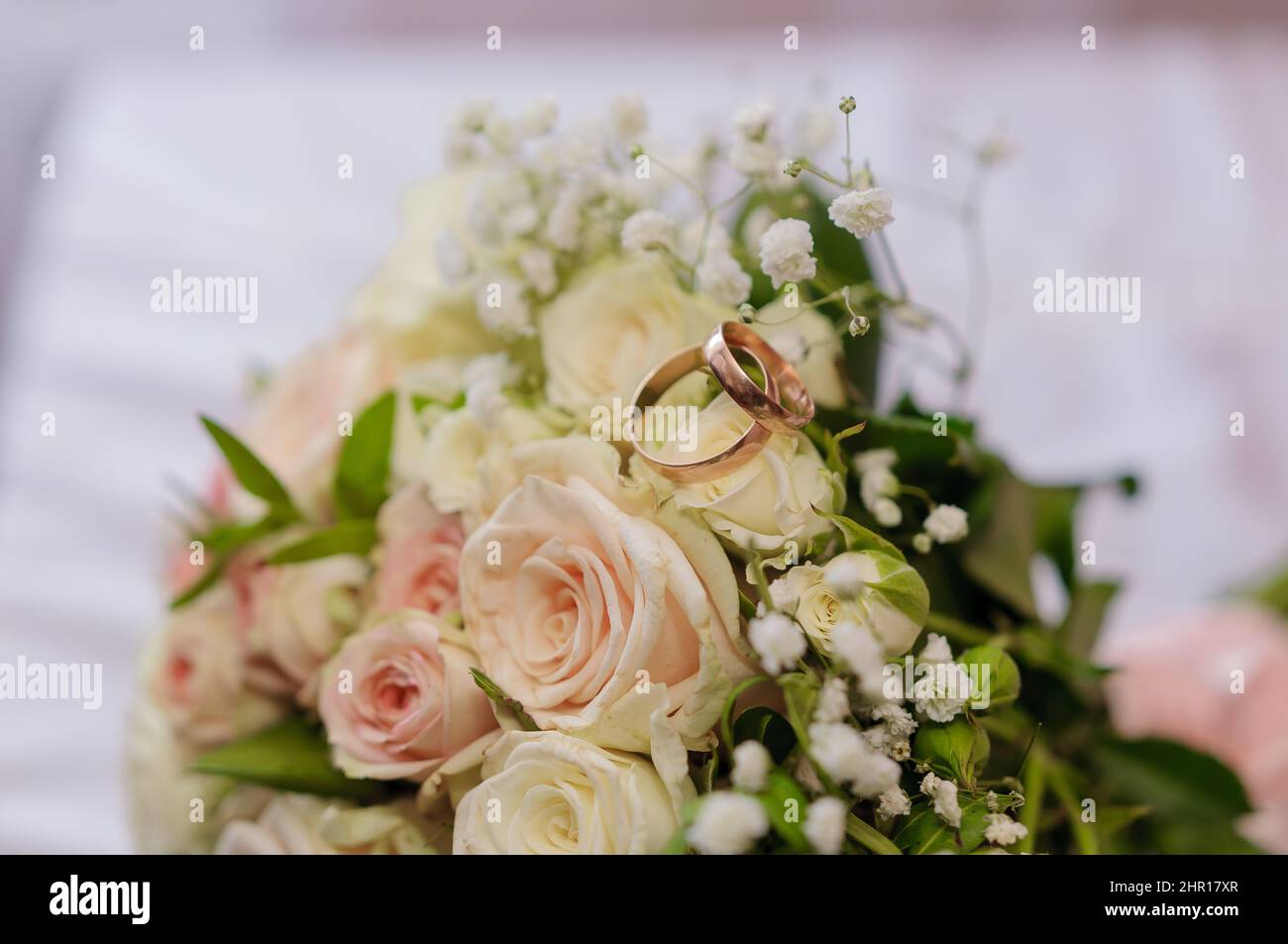 Beautiful bridal bouquet, pair of gold wedding rings Stock Photo