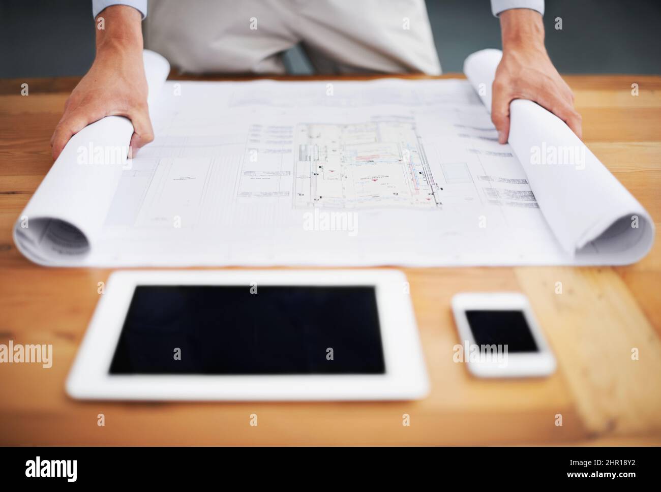 Rolling out the plans. Cropped image of an architect going over his ...